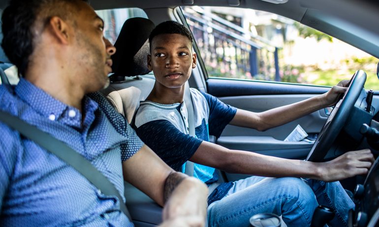 father teaching son to drive